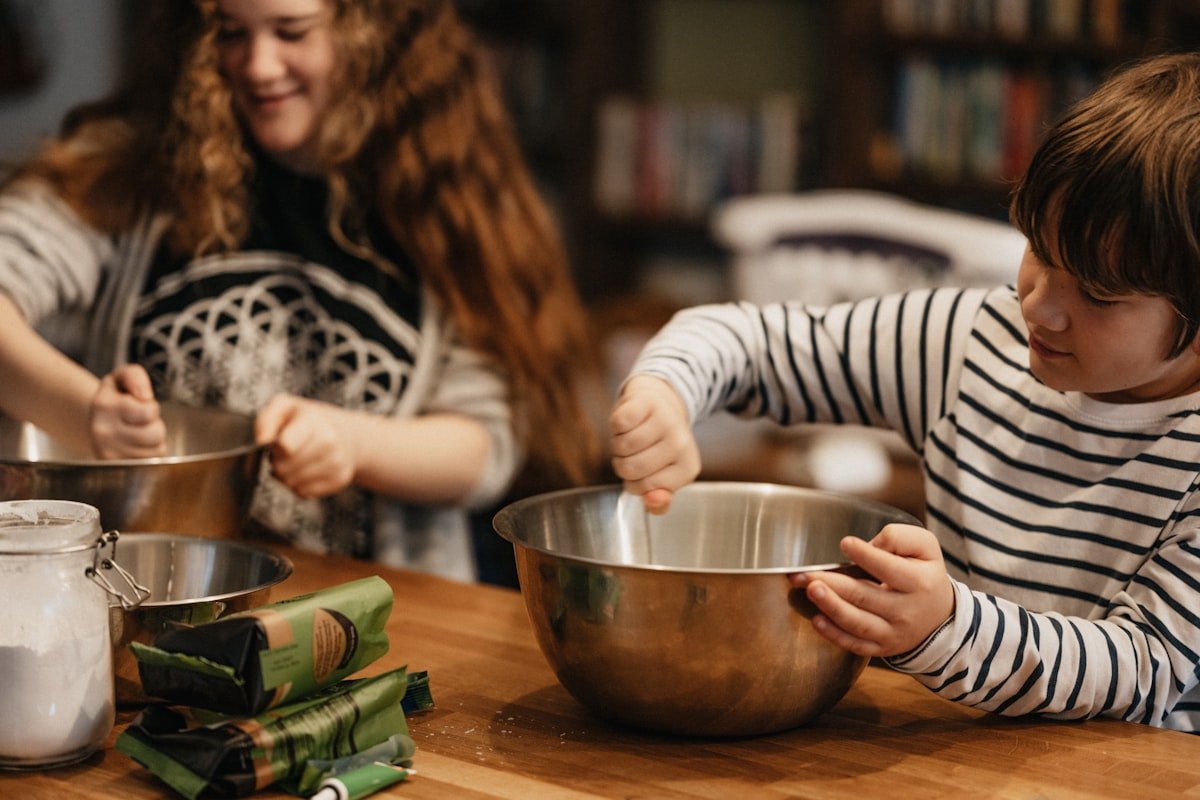 Children mixing ingredients in a bowl during Chef's Corner class